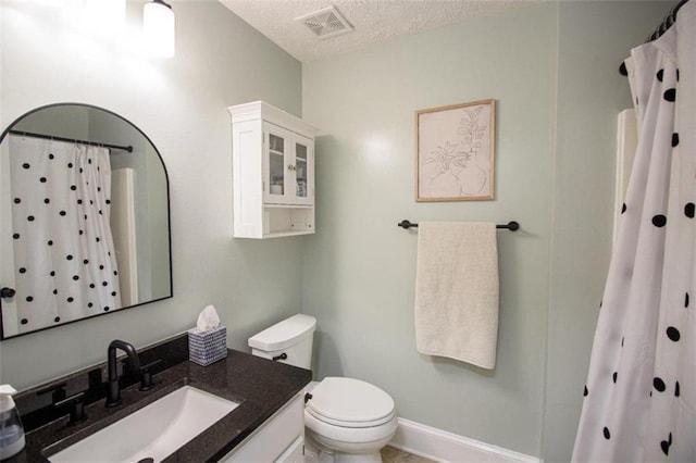 bathroom featuring vanity, curtained shower, a textured ceiling, and toilet