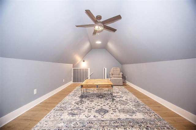 living area with light hardwood / wood-style flooring, ceiling fan, and vaulted ceiling