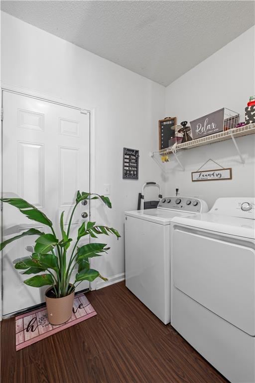 laundry area with laundry area, a textured ceiling, dark wood finished floors, and washer and dryer