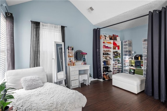 bedroom with dark wood-type flooring, visible vents, and vaulted ceiling