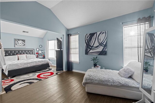 bedroom featuring lofted ceiling, baseboards, visible vents, and wood finished floors