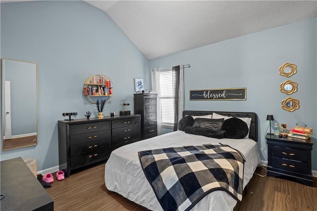 bedroom featuring vaulted ceiling, a textured ceiling, wood finished floors, and baseboards