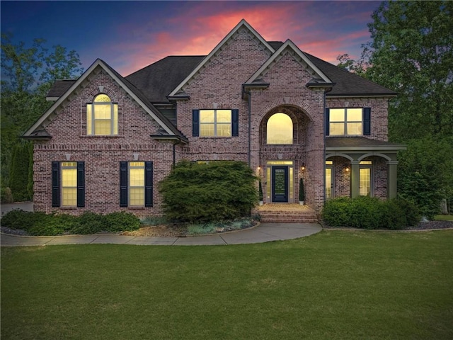 traditional home with a front yard and brick siding