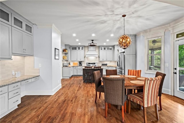 dining area featuring crown molding, baseboards, a chandelier, dark wood-style flooring, and recessed lighting