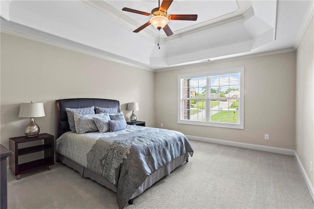 bedroom with a tray ceiling, light colored carpet, ornamental molding, baseboards, and ceiling fan