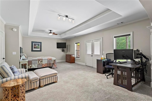 carpeted bedroom with a tray ceiling, ornamental molding, an office area, and baseboards