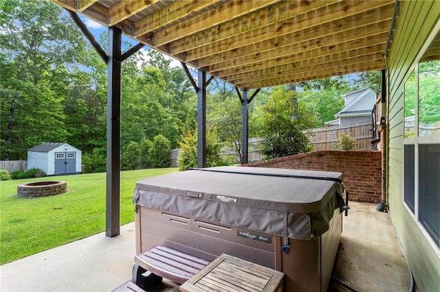 view of patio featuring a fire pit, a hot tub, a shed, and an outdoor structure