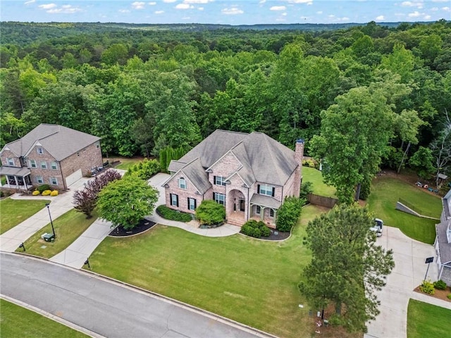 aerial view of property and surrounding area with a heavily wooded area