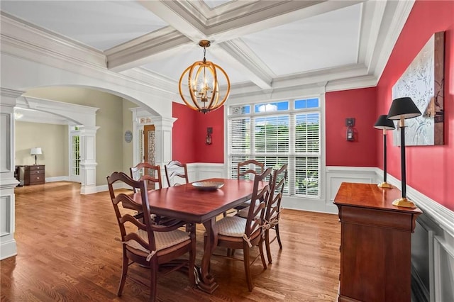 dining room featuring ornate columns, arched walkways, a chandelier, coffered ceiling, and beam ceiling
