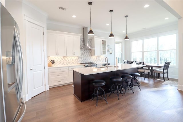 50 Quiet Cove Way, Monticello, GA 31064 - kitchen featuring stainless steel fridge, wall chimney exhaust hood, a sink, a kitchen breakfast bar, and a kitchen island with sink