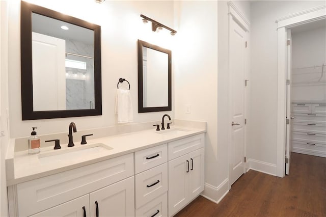 50 Quiet Cove Way, Monticello, GA 31064 - bathroom with wood finished floors, double vanity, a marble finish shower, baseboards, and a spacious closet