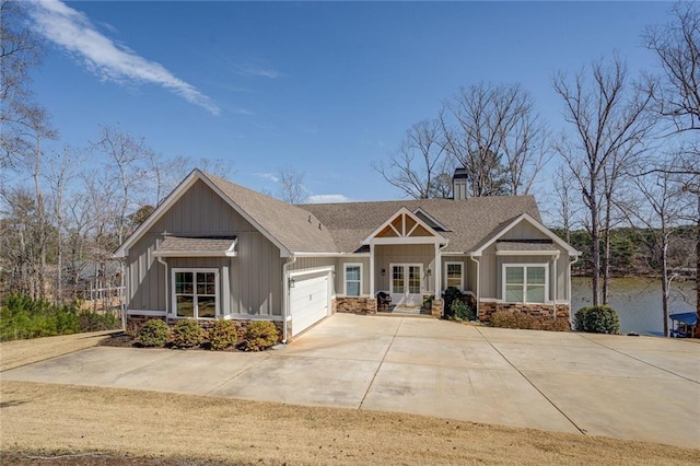 50 Quiet Cove Way, Monticello, GA 31064 - craftsman-style house featuring an attached garage, a chimney, driveway, stone siding, and board and batten siding