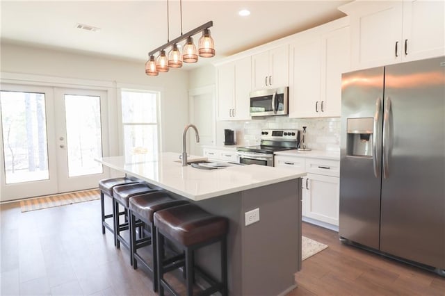 50 Quiet Cove Way, Monticello, GA 31064 - kitchen featuring stainless steel appliances, a sink, decorative backsplash, a kitchen breakfast bar, and a center island with sink