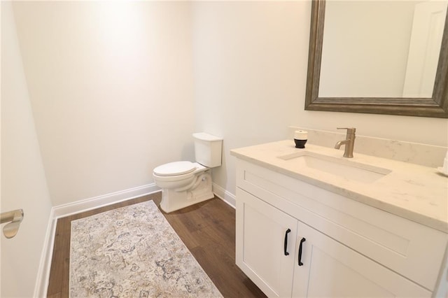 50 Quiet Cove Way, Monticello, GA 31064 - half bathroom with toilet, wood finished floors, vanity, and baseboards