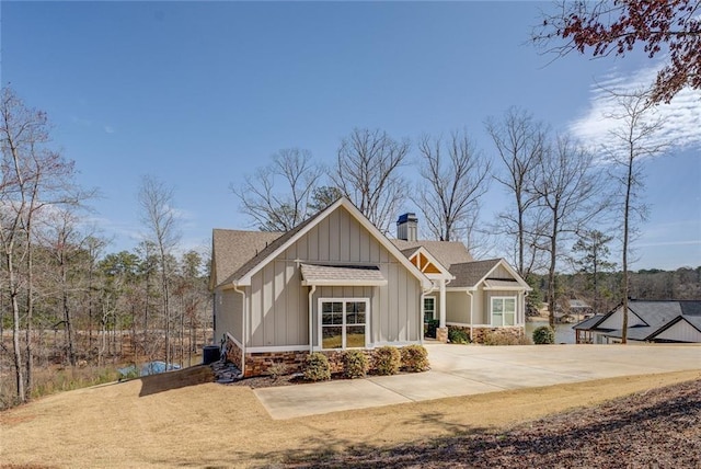 50 Quiet Cove Way, Monticello, GA 31064 - view of front of home featuring board and batten siding, a chimney, central air condition unit, and roof with shingles