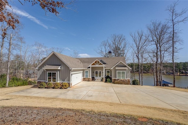 50 Quiet Cove Way, Monticello, GA 31064 - craftsman inspired home featuring an attached garage, driveway, a water view, board and batten siding, and stone siding