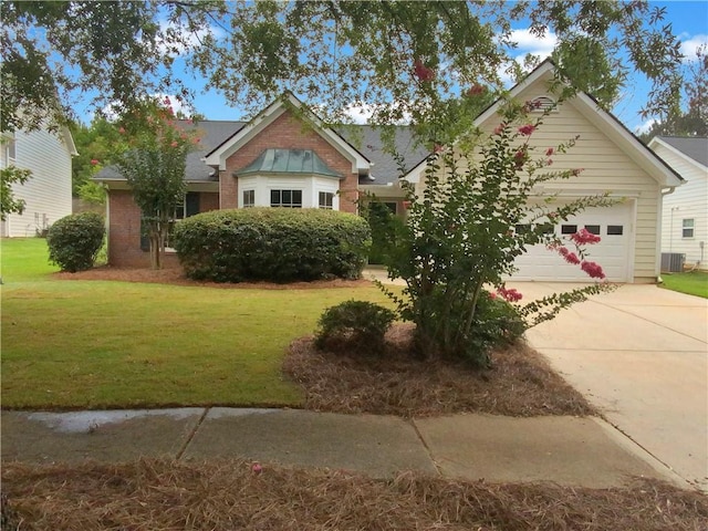 view of front of property with a garage, central AC, and a front lawn