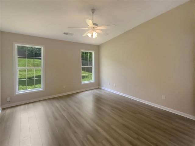 empty room featuring ceiling fan, wood-type flooring, and a healthy amount of sunlight