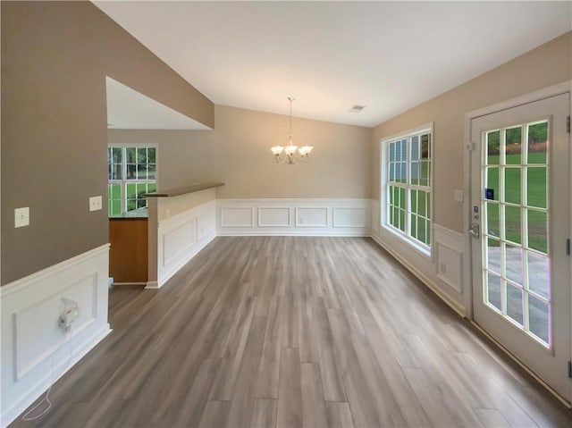 unfurnished dining area featuring hardwood / wood-style floors and a chandelier