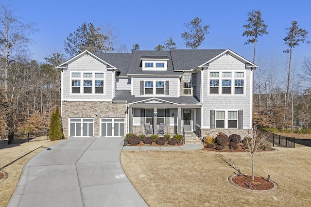 view of front facade with covered porch, a garage, and a front lawn