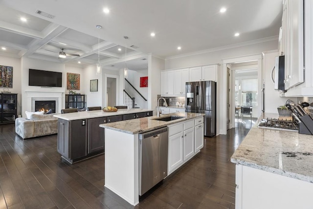 kitchen featuring coffered ceiling, a center island with sink, appliances with stainless steel finishes, beam ceiling, and white cabinetry