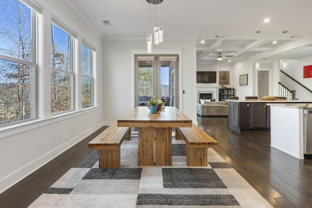 dining area with beam ceiling, ceiling fan, dark wood-type flooring, coffered ceiling, and ornamental molding