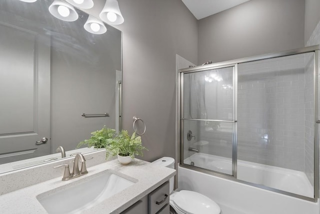 full bathroom with vanity, toilet, and enclosed tub / shower combo