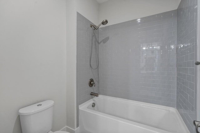 bathroom featuring toilet and tiled shower / bath