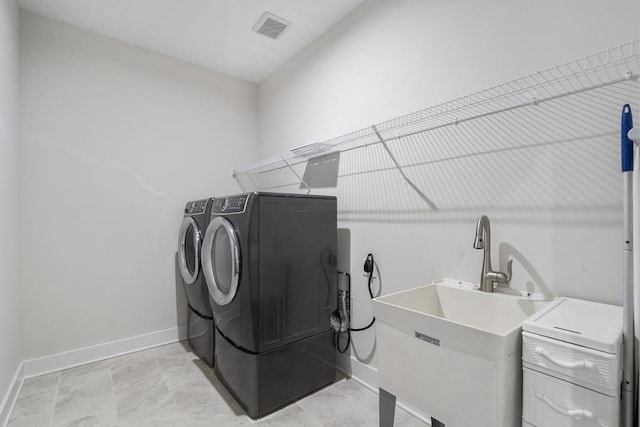 washroom featuring washing machine and dryer and sink