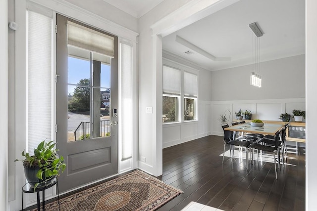 dining area with a raised ceiling, a wealth of natural light, and dark hardwood / wood-style flooring