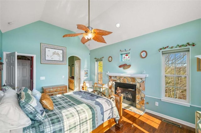 bedroom with lofted ceiling, a fireplace, wood-type flooring, and ceiling fan