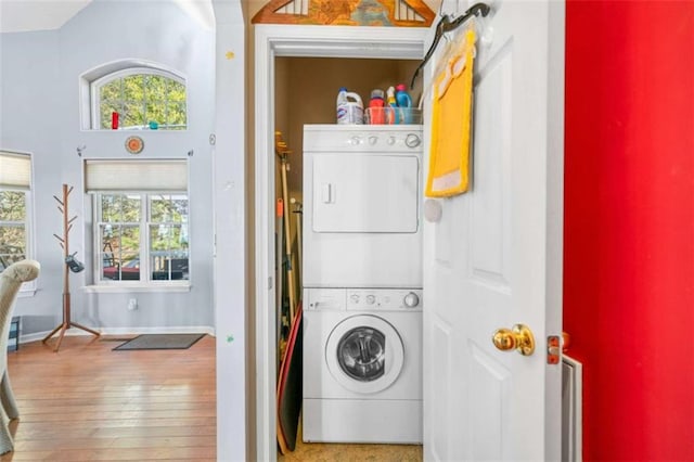 washroom with stacked washer / dryer and wood-type flooring