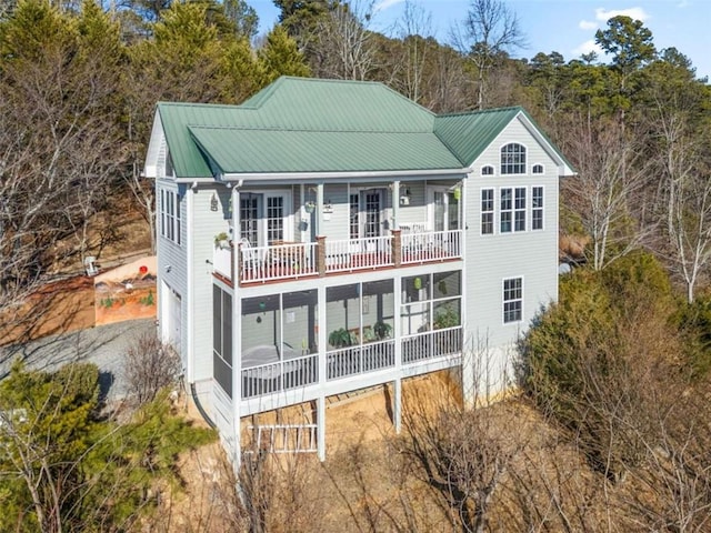 back of property featuring a balcony and a sunroom