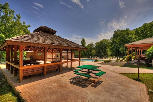 view of property's community featuring a gazebo, a swimming pool, and a patio