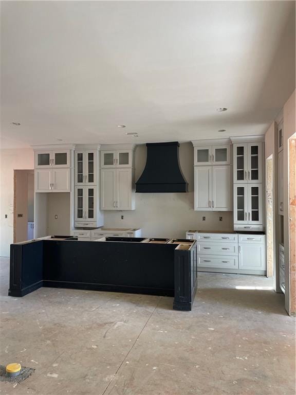 6355 Little Mill Rd, Gainesville, GA 30506 - kitchen featuring wall chimney exhaust hood, white cabinetry, a center island, and glass insert cabinets