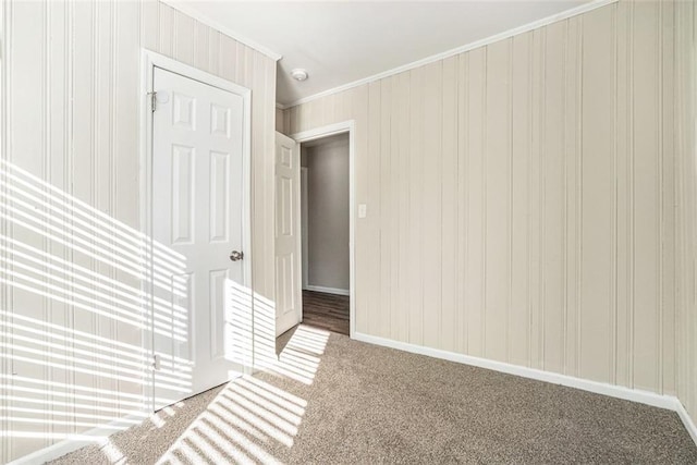 spare room with ornamental molding and carpet flooring