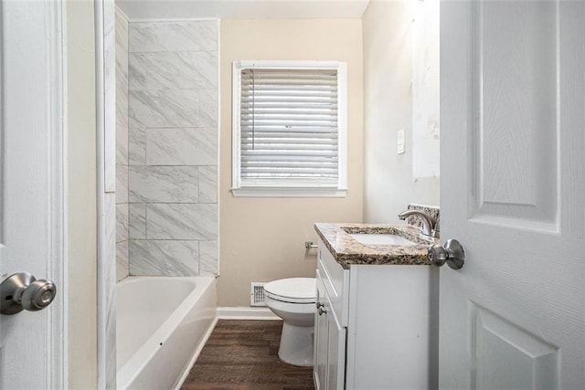 full bathroom with hardwood / wood-style flooring, shower / tub combination, toilet, and vanity