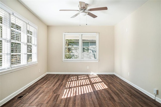 spare room with plenty of natural light and dark hardwood / wood-style flooring