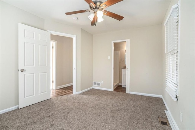 unfurnished bedroom with ceiling fan, ensuite bathroom, and carpet flooring