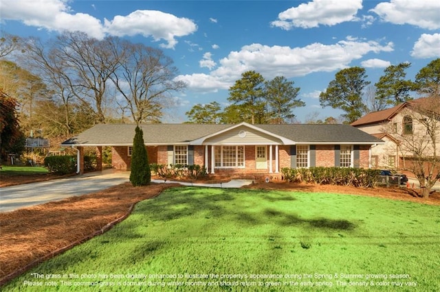 view of front of home featuring brick siding, driveway, a carport, and a front yard