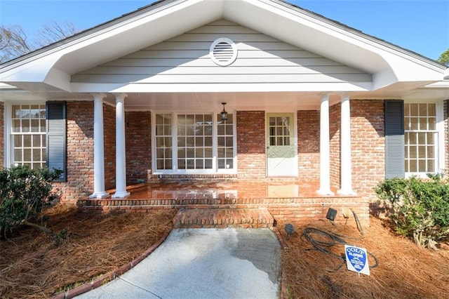 view of front facade with brick siding and covered porch