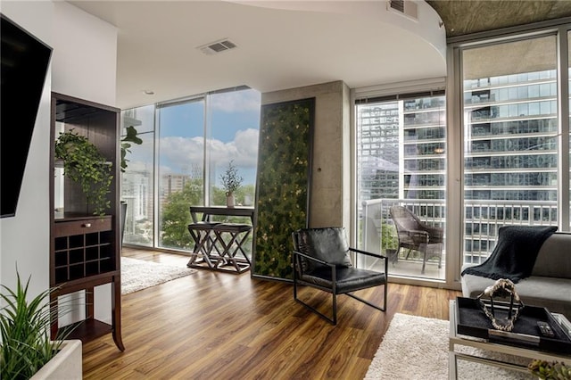 living area with hardwood / wood-style flooring and a wall of windows