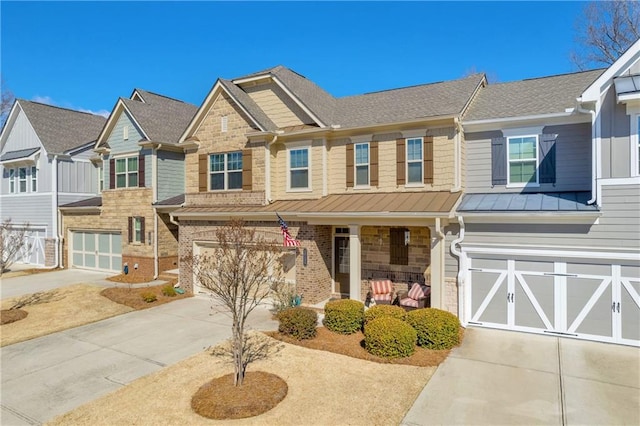 view of front of home featuring a porch, brick siding, driveway, stone siding, and a standing seam roof