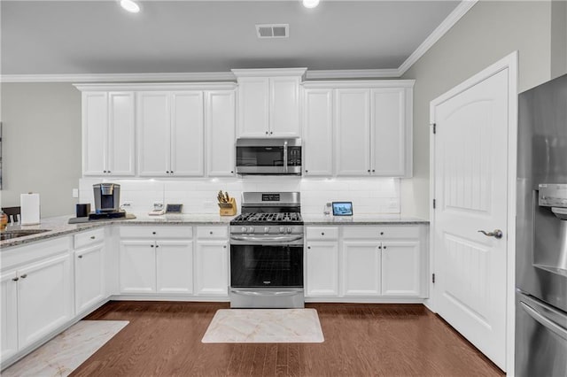 2735 Kimblewick Ct, Cumming, GA 30040 - kitchen featuring stainless steel appliances, visible vents, white cabinetry, ornamental molding, and dark wood-style floors