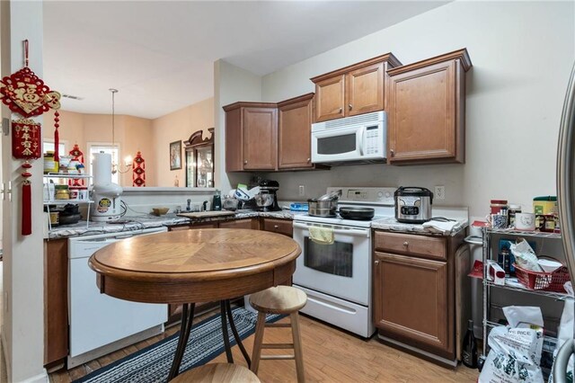 3829 Thayer Trce, Duluth, GA 30096 - kitchen featuring white appliances, light wood finished floors, a sink, brown cabinetry, and light stone counters