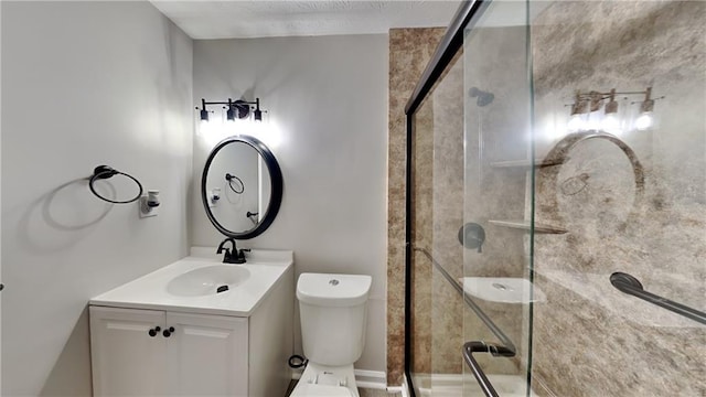 bathroom featuring vanity, a shower with shower door, and toilet