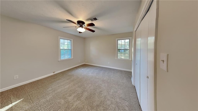 carpeted spare room featuring ceiling fan