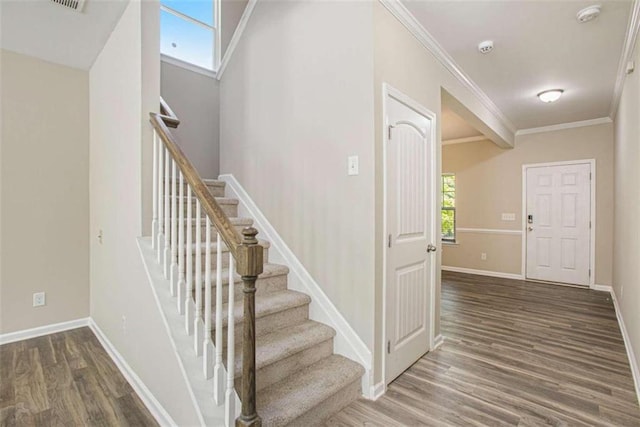 stairway featuring crown molding and wood-type flooring