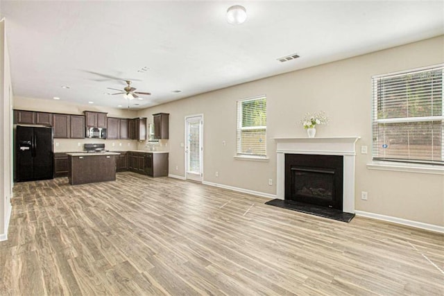 unfurnished living room with light wood-type flooring and ceiling fan