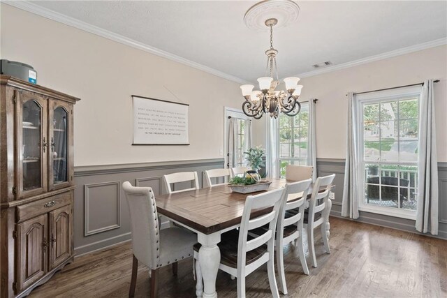 dining space featuring ornamental molding, a notable chandelier, and dark hardwood / wood-style floors